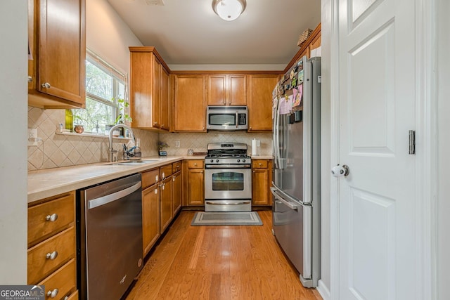 2705 Maple Park Pl Unit 29, Cumming, GA 30041 - kitchen with light countertops, a sink, brown cabinetry, and appliances with stainless steel finishes