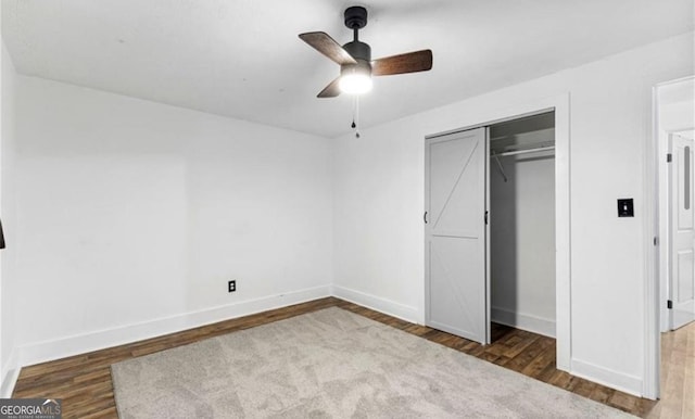 unfurnished bedroom with baseboards, a closet, wood finished floors, and a ceiling fan