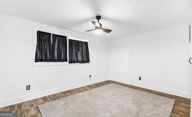 unfurnished room featuring baseboards, wood finished floors, and a ceiling fan