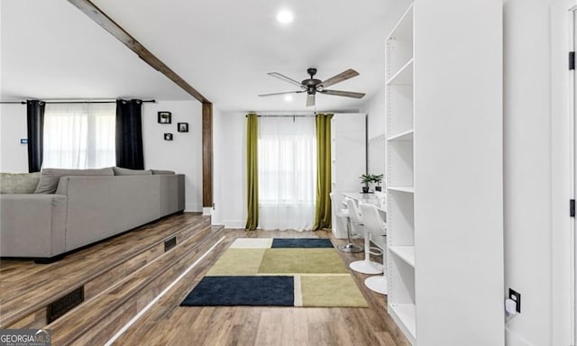 living area with wood finished floors, visible vents, and ceiling fan
