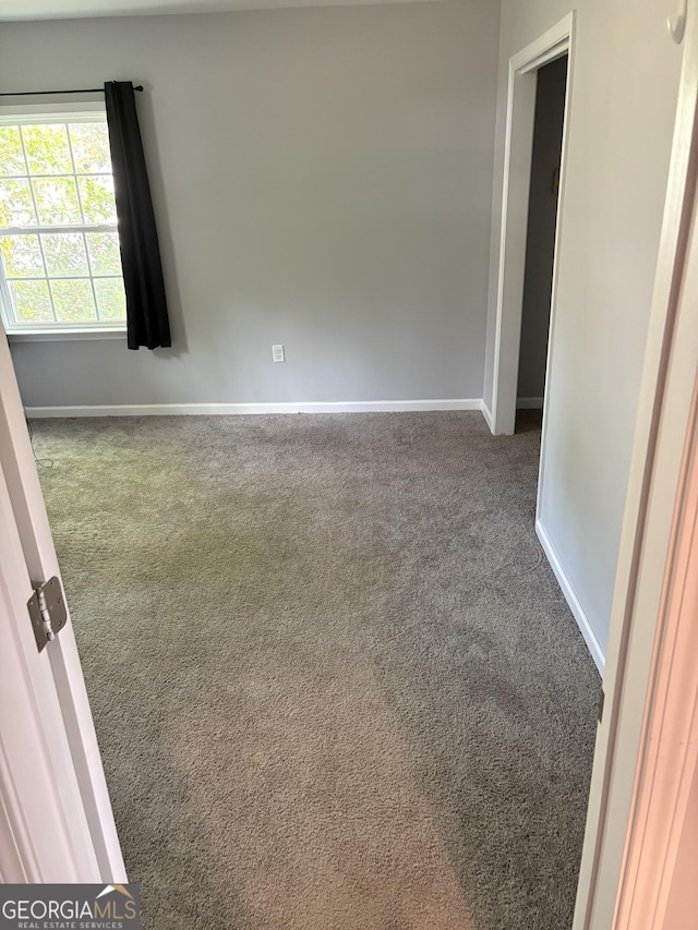 carpeted spare room with baseboards