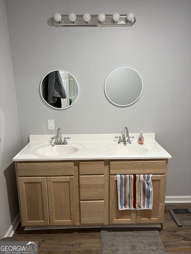 full bathroom with double vanity, baseboards, and a sink