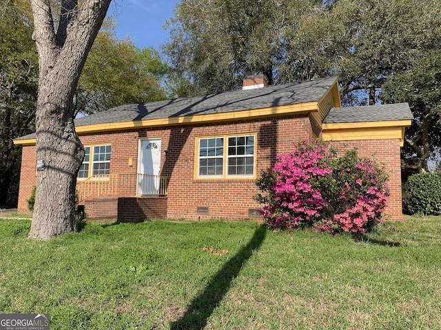 view of front of house with brick siding, crawl space, a front yard, and a chimney