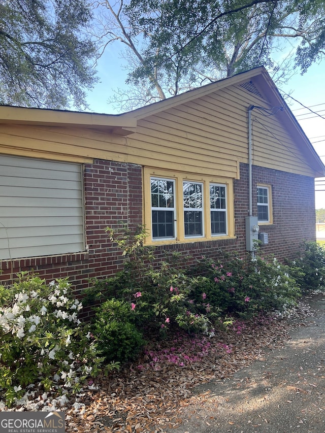 view of side of home featuring brick siding