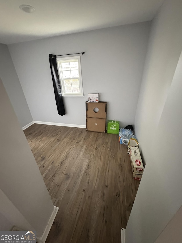unfurnished room with baseboards and wood finished floors