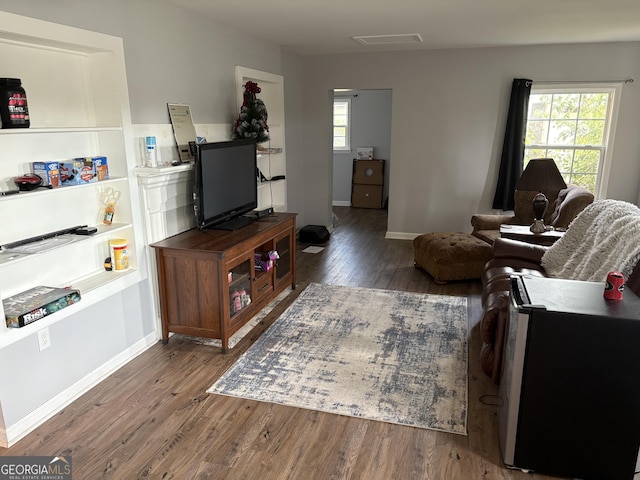 living area with baseboards and wood finished floors