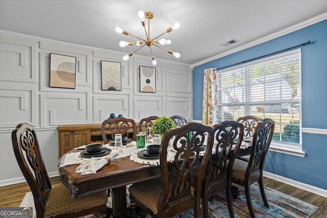 dining space featuring wood finished floors, visible vents, ornamental molding, and a notable chandelier