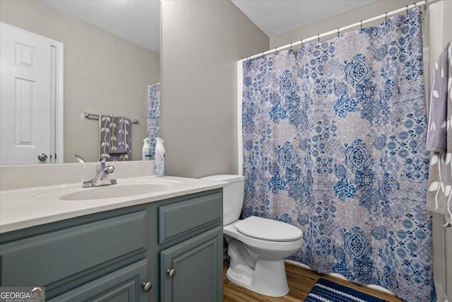 bathroom with toilet, a shower with shower curtain, vanity, and wood finished floors