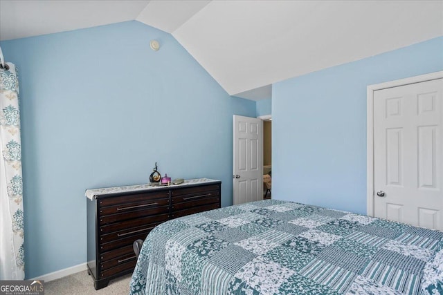 bedroom with baseboards, vaulted ceiling, and light carpet