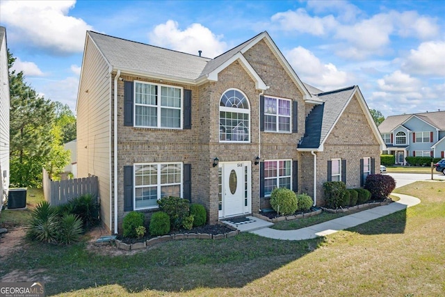 colonial inspired home featuring central AC, a front lawn, fence, and brick siding