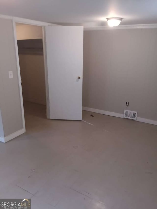 basement with baseboards and visible vents