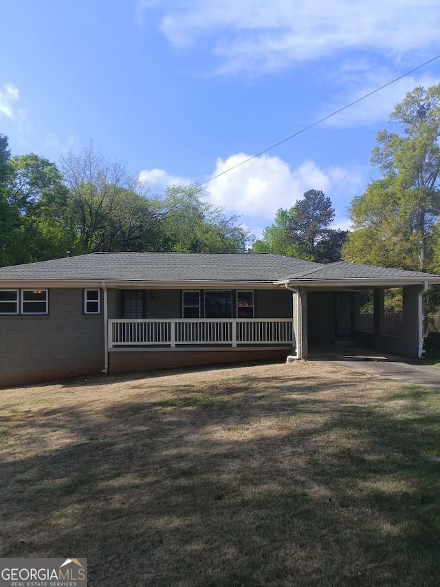 view of front of home featuring covered porch, a front yard, and a carport