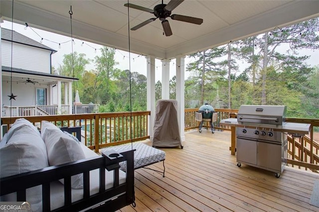 wooden deck featuring ceiling fan and a grill