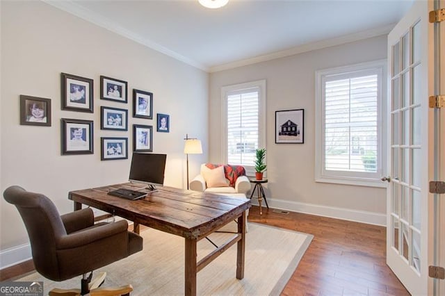 office space with french doors, ornamental molding, baseboards, and wood finished floors