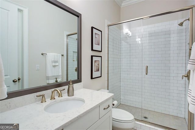 full bath featuring a shower stall, vanity, ornamental molding, and toilet