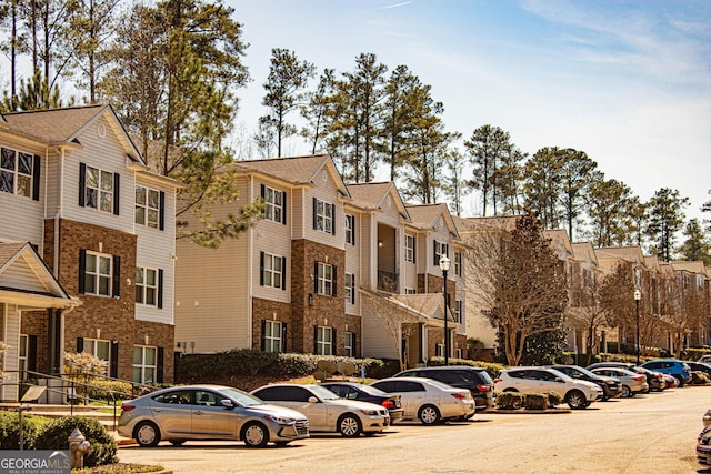 view of building exterior featuring a residential view and uncovered parking