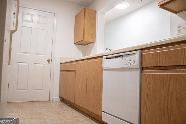 kitchen featuring light countertops, light tile patterned flooring, white dishwasher, and light brown cabinetry