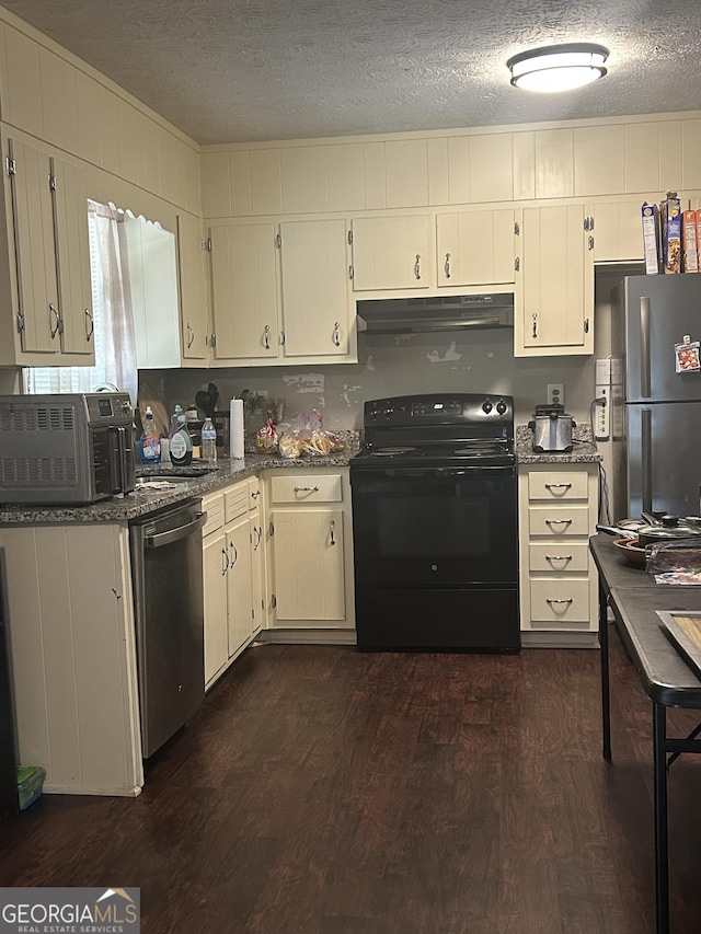 kitchen featuring dark stone countertops, a textured ceiling, stainless steel appliances, under cabinet range hood, and dark wood-type flooring