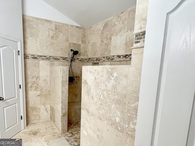 bathroom with a walk in shower and lofted ceiling