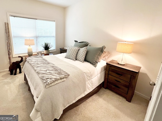 bedroom featuring baseboards and light colored carpet