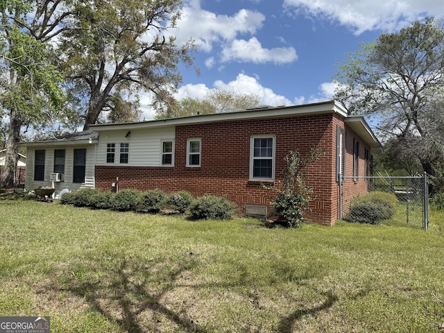 back of property featuring brick siding and a lawn