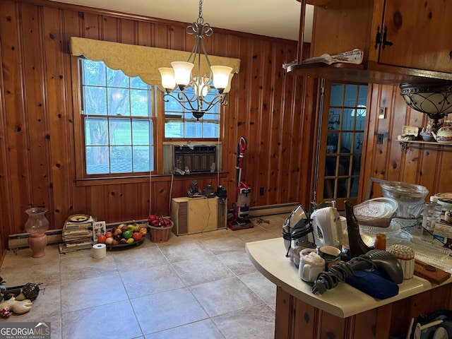 dining room featuring light tile patterned flooring, a baseboard radiator, a notable chandelier, and wood walls