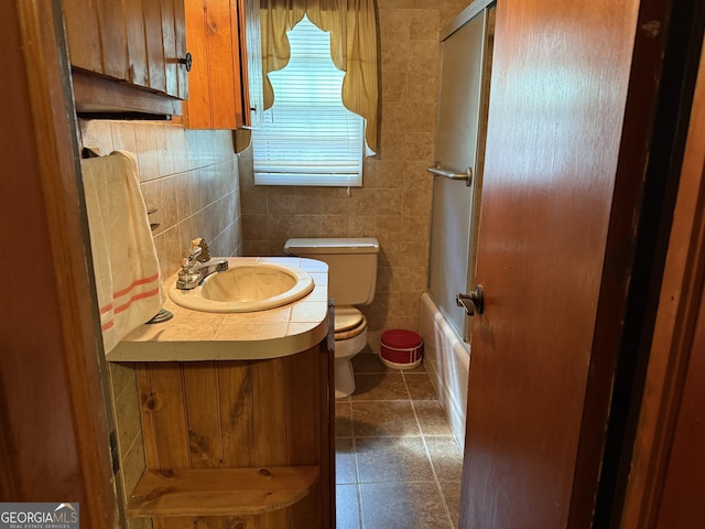 full bathroom with tile patterned flooring, vanity, tile walls, toilet, and enclosed tub / shower combo