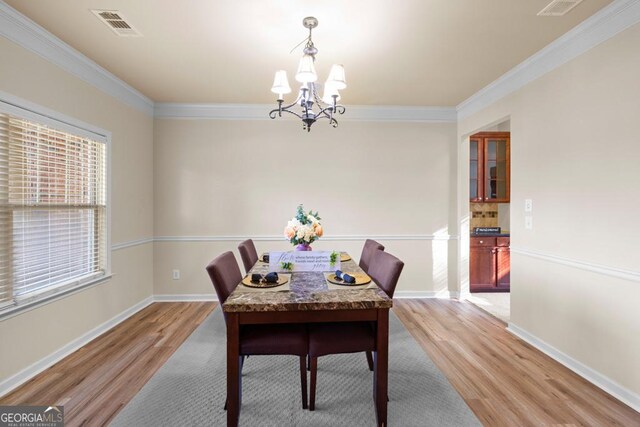 2694 Dawning Day Dr, Dacula, GA 30019 - dining room featuring an inviting chandelier, baseboards, light wood-type flooring, visible vents, and ornamental molding