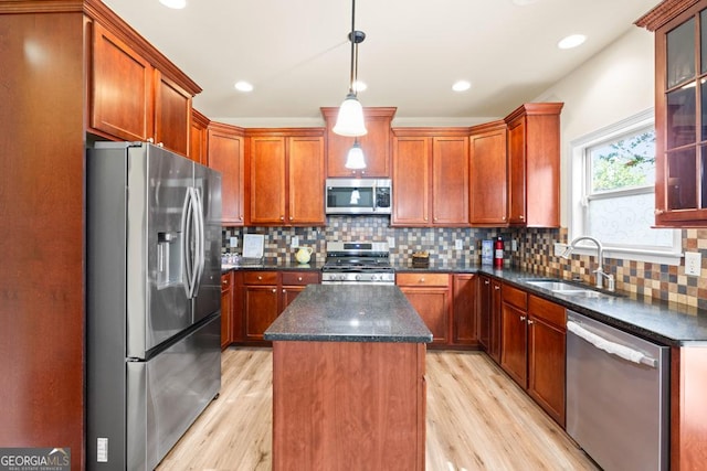 2694 Dawning Day Dr, Dacula, GA 30019 - kitchen with a kitchen island, appliances with stainless steel finishes, tasteful backsplash, a sink, and light wood-style floors