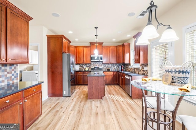2694 Dawning Day Dr, Dacula, GA 30019 - kitchen featuring stainless steel appliances, visible vents, washing machine and dryer, and light wood-style floors