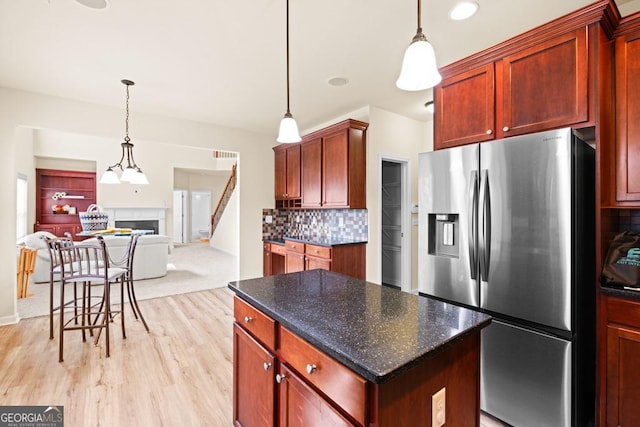 2694 Dawning Day Dr, Dacula, GA 30019 - kitchen with a fireplace, open floor plan, light wood-type flooring, stainless steel fridge with ice dispenser, and backsplash