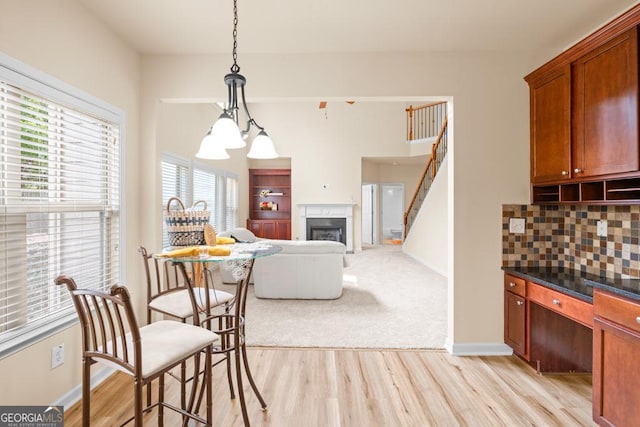 2694 Dawning Day Dr, Dacula, GA 30019 - kitchen featuring a fireplace, backsplash, a healthy amount of sunlight, and light wood-type flooring