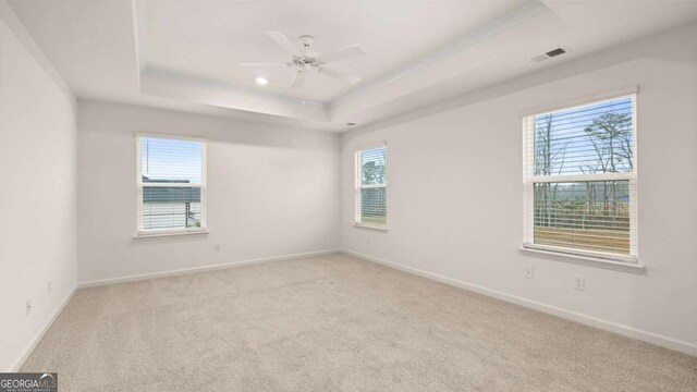 1129 Blue Juniper Cir, Loganville, GA 30052 - carpeted empty room with baseboards, visible vents, ceiling fan, and a raised ceiling
