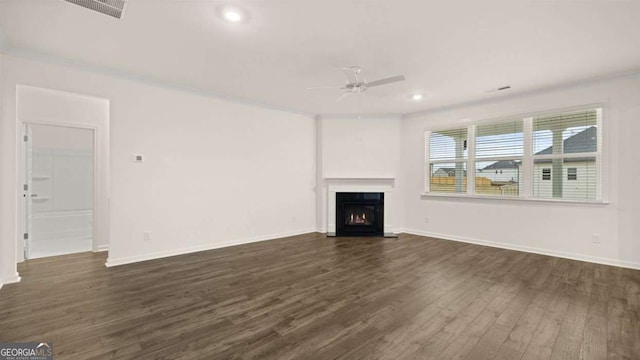 1129 Blue Juniper Cir, Loganville, GA 30052 - unfurnished living room with a warm lit fireplace, visible vents, baseboards, a ceiling fan, and dark wood-style floors