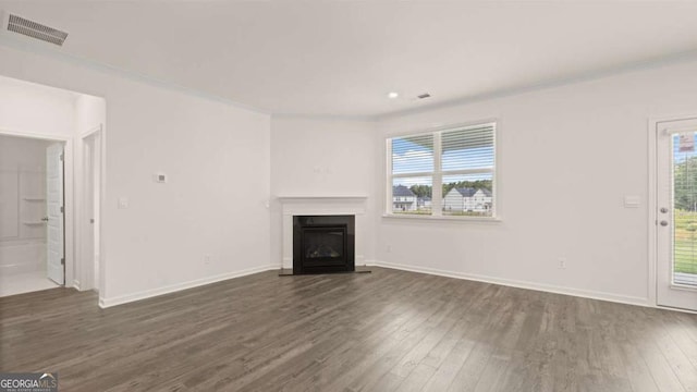 unfurnished living room with a fireplace with flush hearth, baseboards, dark wood-type flooring, and visible vents