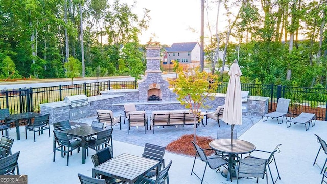 view of patio with a grill, area for grilling, fence, outdoor dining space, and an outdoor living space with a fireplace