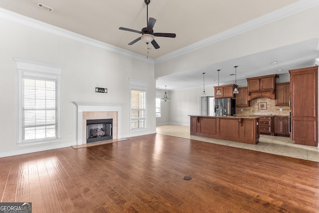 157 Wessex Dr, Bonaire, GA 31005 - unfurnished living room with light wood finished floors, ceiling fan, a fireplace, ornamental molding, and a chandelier