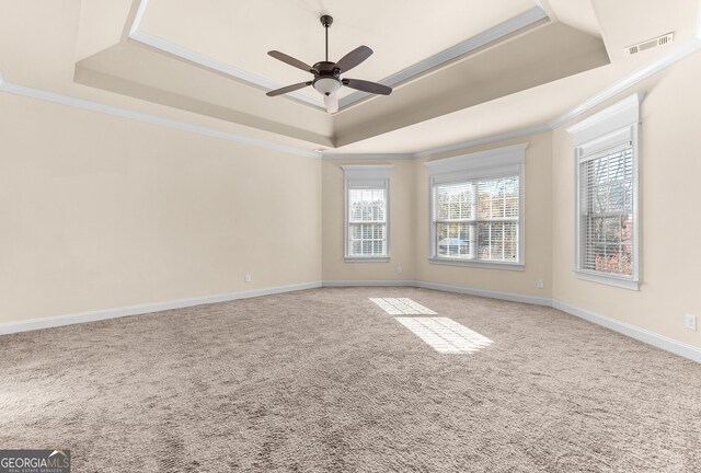 157 Wessex Dr, Bonaire, GA 31005 - spare room featuring a tray ceiling, healthy amount of natural light, ornamental molding, light colored carpet, and a ceiling fan