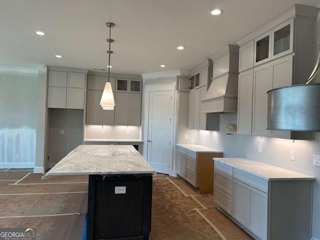 kitchen with glass insert cabinets, premium range hood, recessed lighting, and a kitchen island