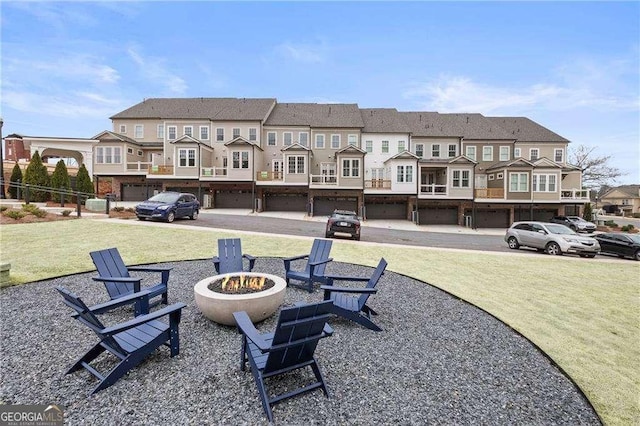 surrounding community featuring an outdoor fire pit, a yard, and a residential view