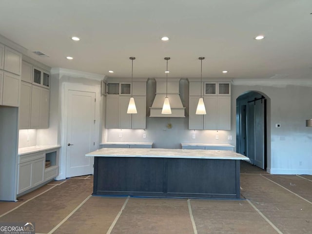 kitchen featuring glass insert cabinets, custom range hood, arched walkways, and a kitchen island