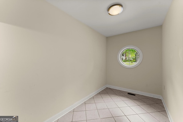 empty room featuring visible vents, baseboards, and light tile patterned flooring