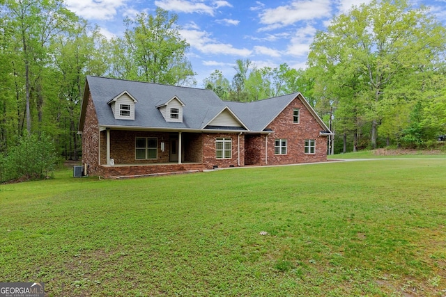 cape cod house with central air condition unit, a shingled roof, a front yard, and brick siding