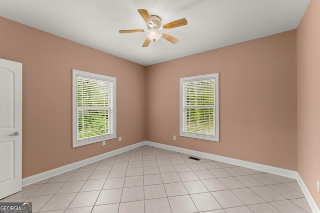 spare room featuring a wealth of natural light, ceiling fan, and baseboards