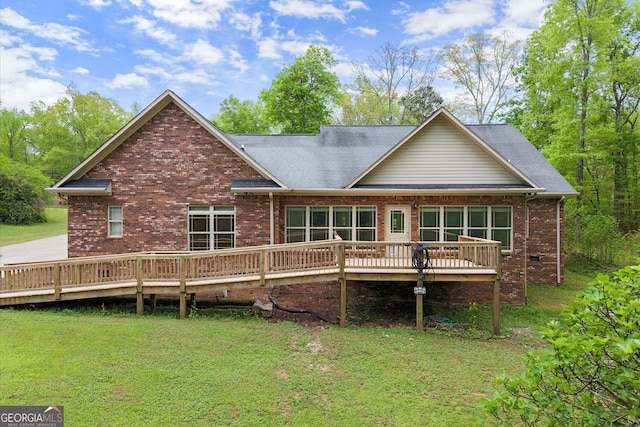 rear view of property with a lawn and brick siding