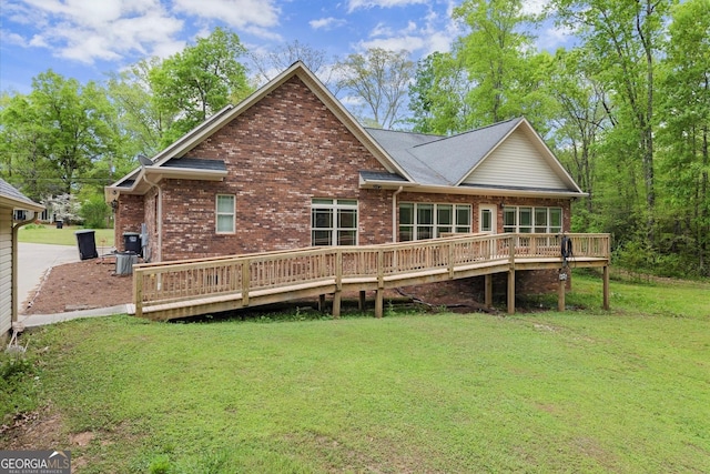 rear view of house with a yard, a wooden deck, and brick siding