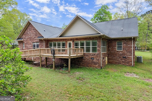 rear view of house with crawl space, a lawn, brick siding, a wooden deck, and roof with shingles