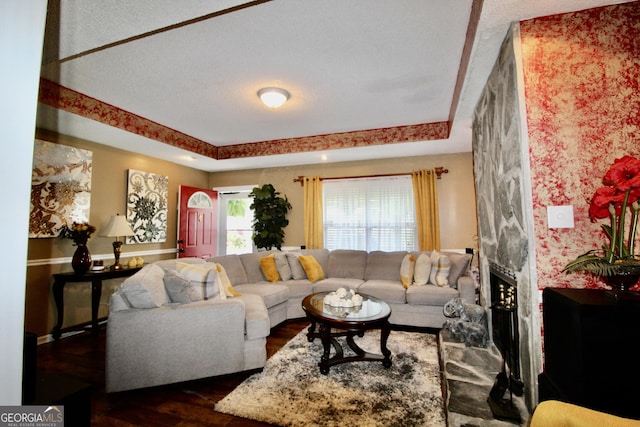 3789 Heatherwoods Dr, Valdosta, GA 31605 - living room featuring a raised ceiling, dark wood-style flooring, and a fireplace