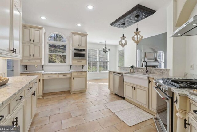 kitchen with cream cabinetry, a sink, visible vents, appliances with stainless steel finishes, and wall chimney exhaust hood