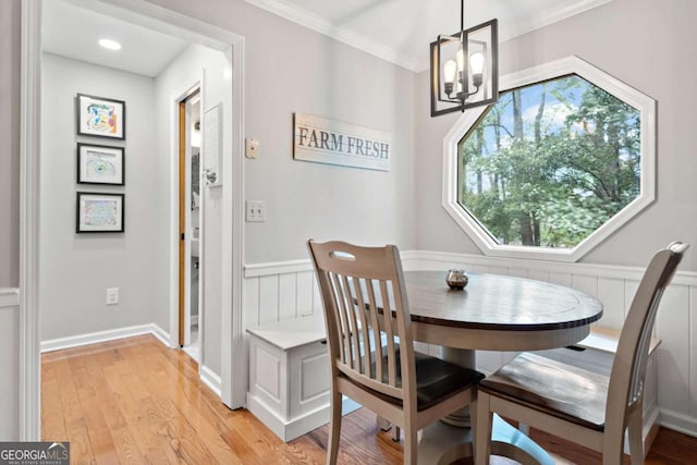 6695 Woodstock Rd, Acworth, GA 30102 - dining space with a notable chandelier, light wood-style flooring, ornamental molding, and wainscoting
